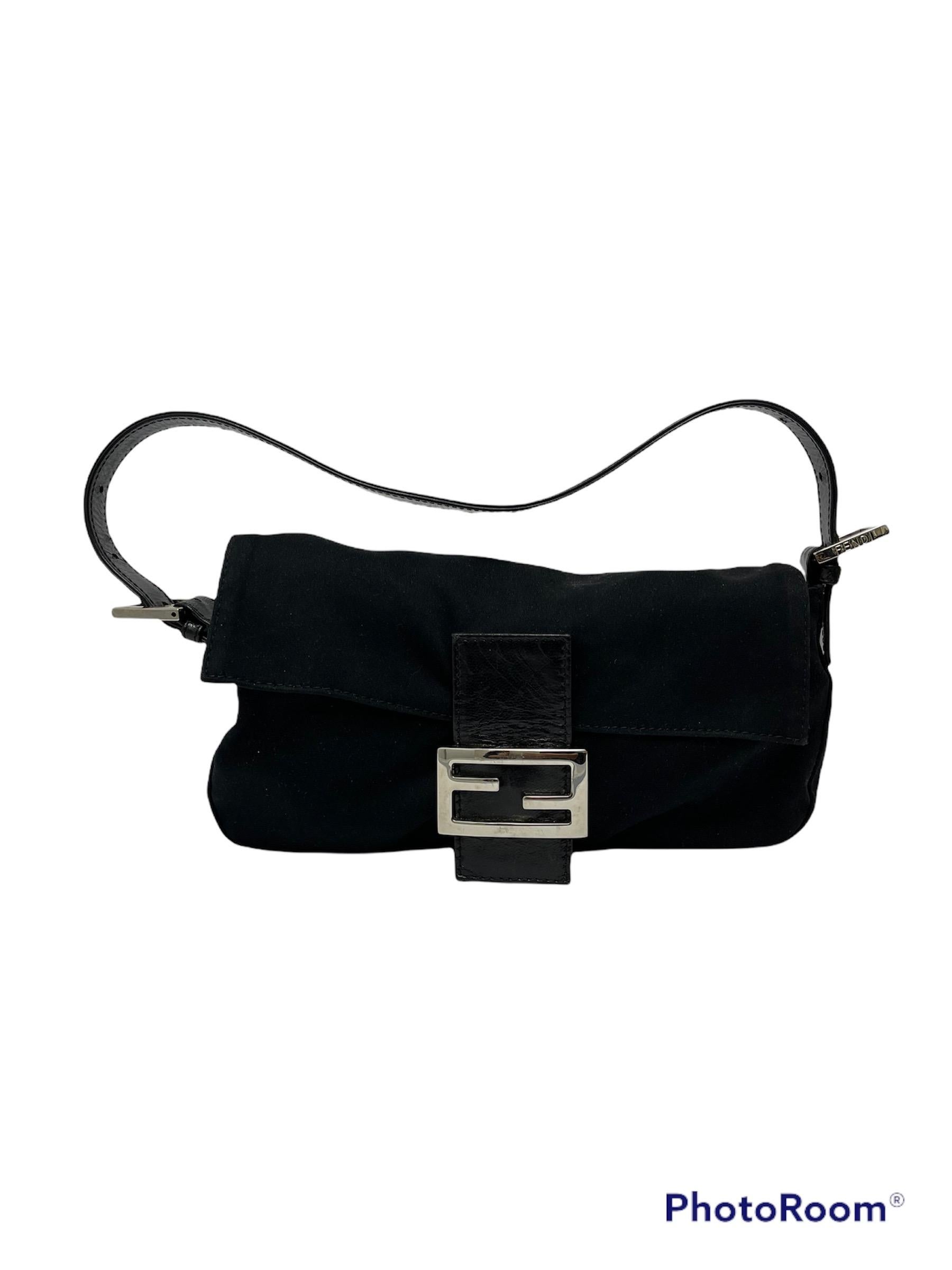 Fendi baguette in soft black fabric with silver leather and hardware.  Adjustable leather handle.  Front flap with magnetic button closure, black interior with side zip pocket.  Condition of the bag in excellent condition, as can be seen in the