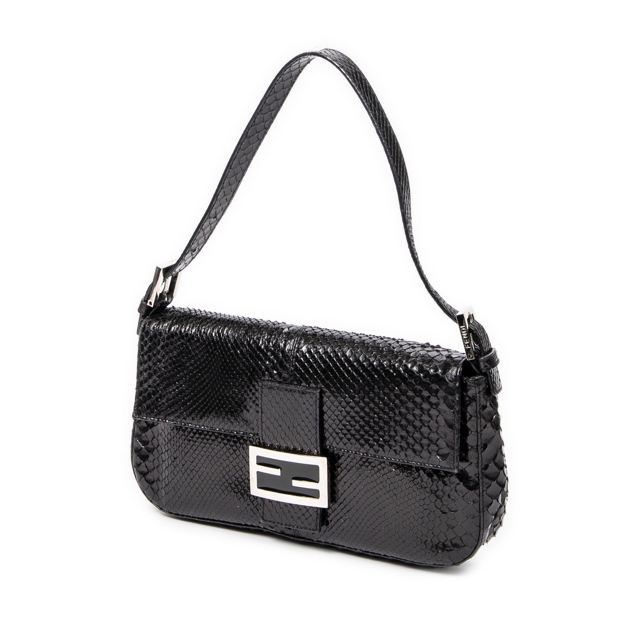 Introducing the Fendi Black Baguette: a sleek and sophisticated addition to your collection. Crafted from luxurious lizard embossed leather in classic black, this bag exudes timeless elegance. Its silver hardware adds a touch of modernity, while the
