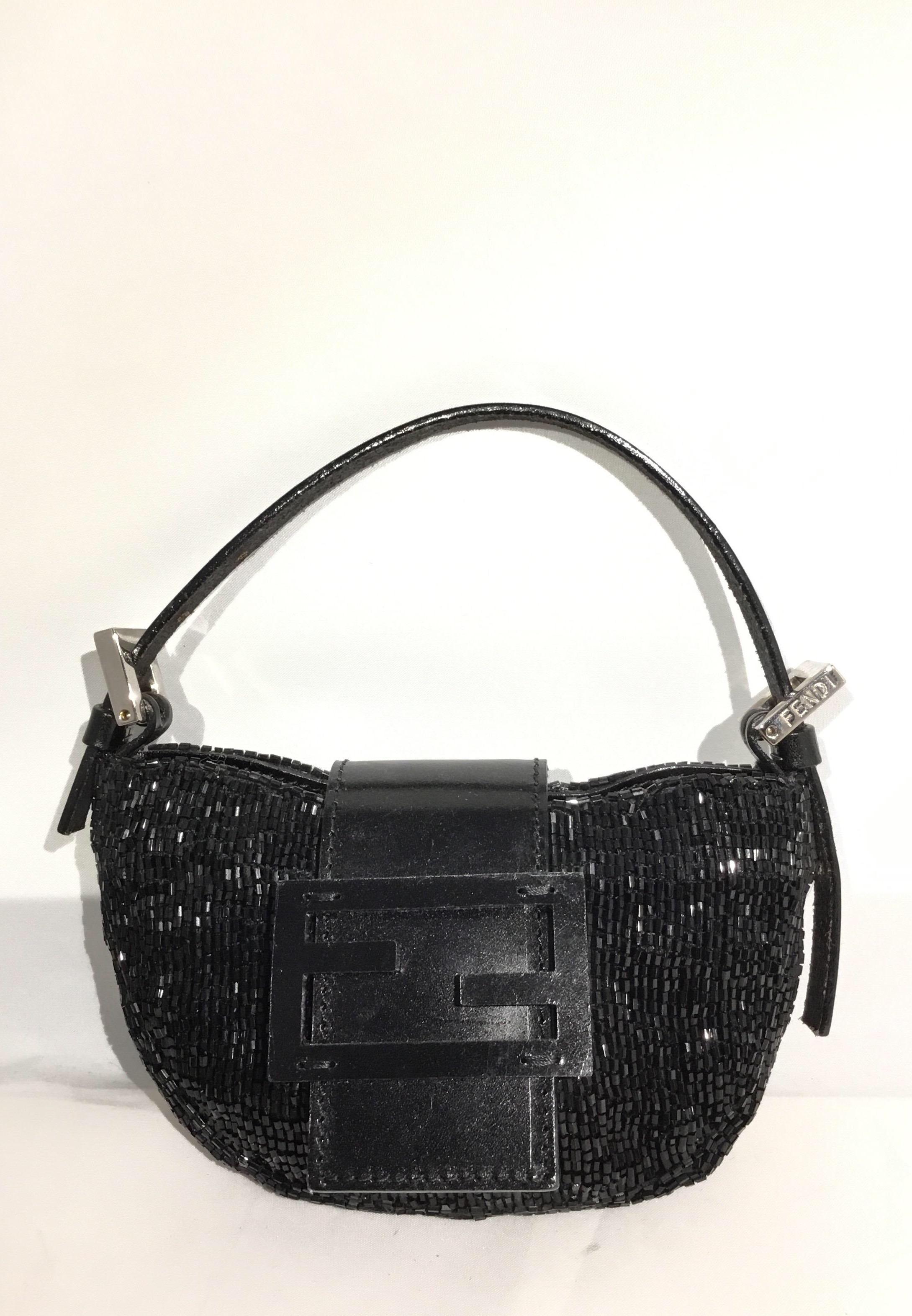 Fendi Mini baguette featured in black and fully beaded with a flat leather top handle attached with silvertone hardware and a signature Fendi flap-snap closure. Bag has a canvas lining and a original dustbag is included. Bag is in excellent