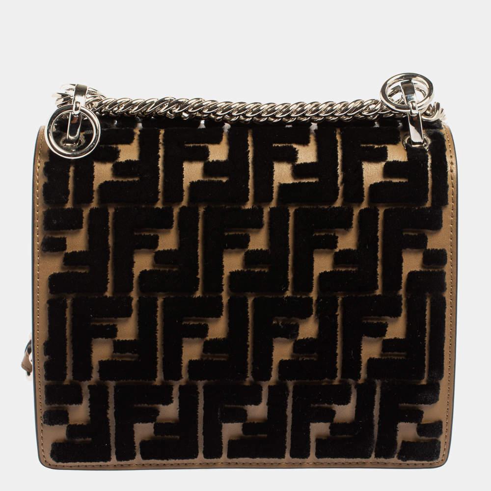 This Kan I F Fendi bag exudes an aura of excellence and an unequaled standard of craftsmanship. It has been crafted from leather and velvet exhibiting the signature Zucca pattern in a black and brown shade and styled with pyramid studs. It opens to