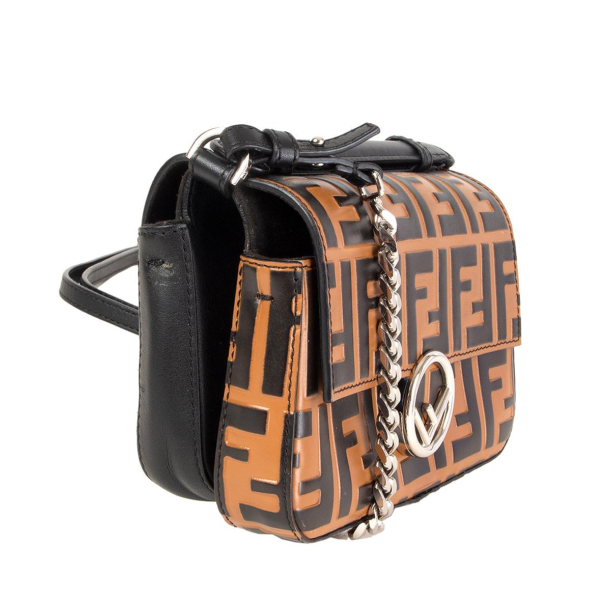100% authentic Fendi 'Double Logo Micro Baguette' shoulder body bag in brown and black Zucca embossed leather and black calfskin featuring a double foldover top with magnetic snap closure, a front logo plaque, a chain strap. Two main internal