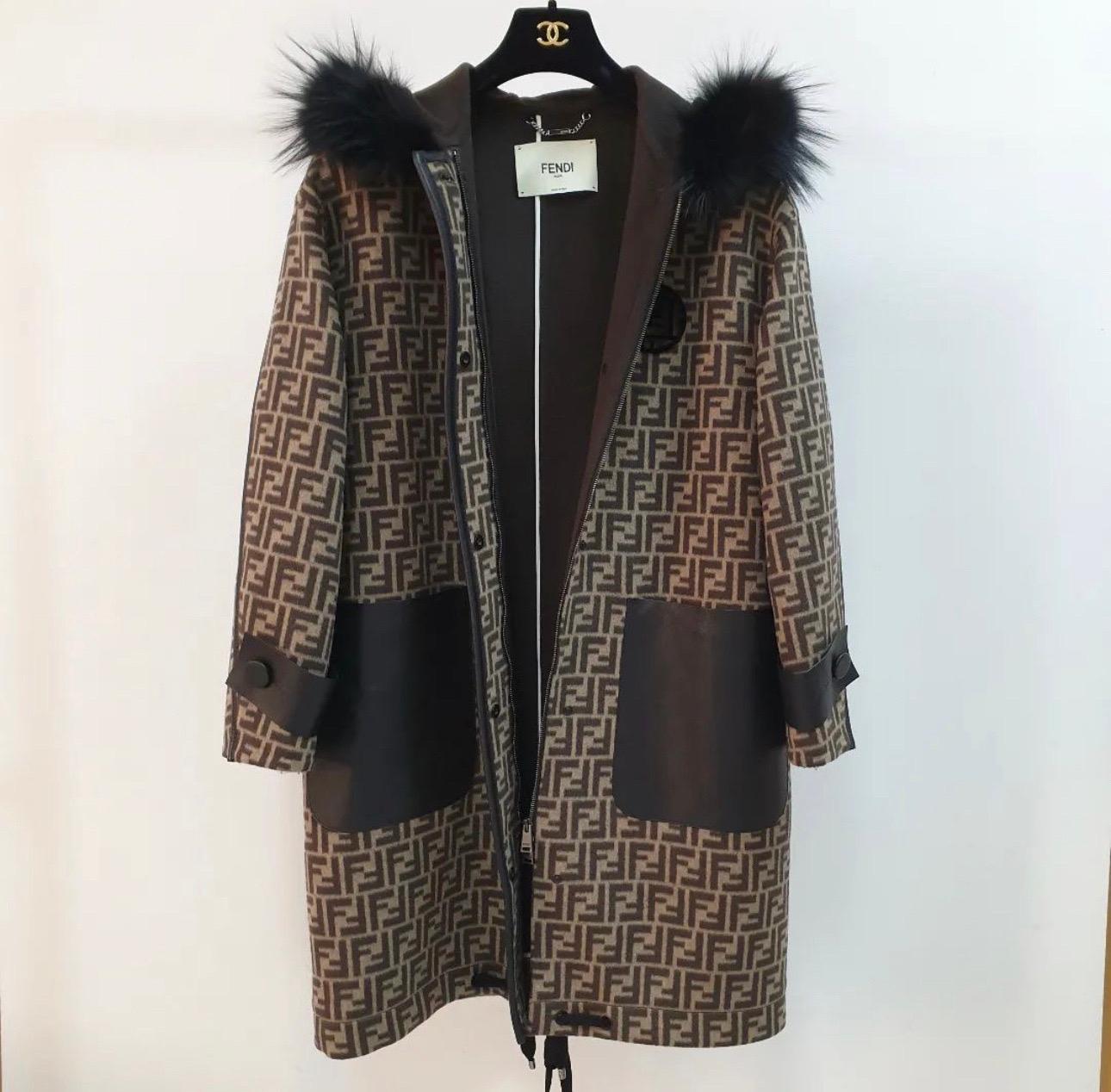 Enhance your winter ensemble with this classy coat from the House of Fendi. 
Fashioned in black-brown FF logo printed wool fabric, this coat is embellished with fur trims, long sleeves, and a zipper fastening. 
Make your winter collection luxurious