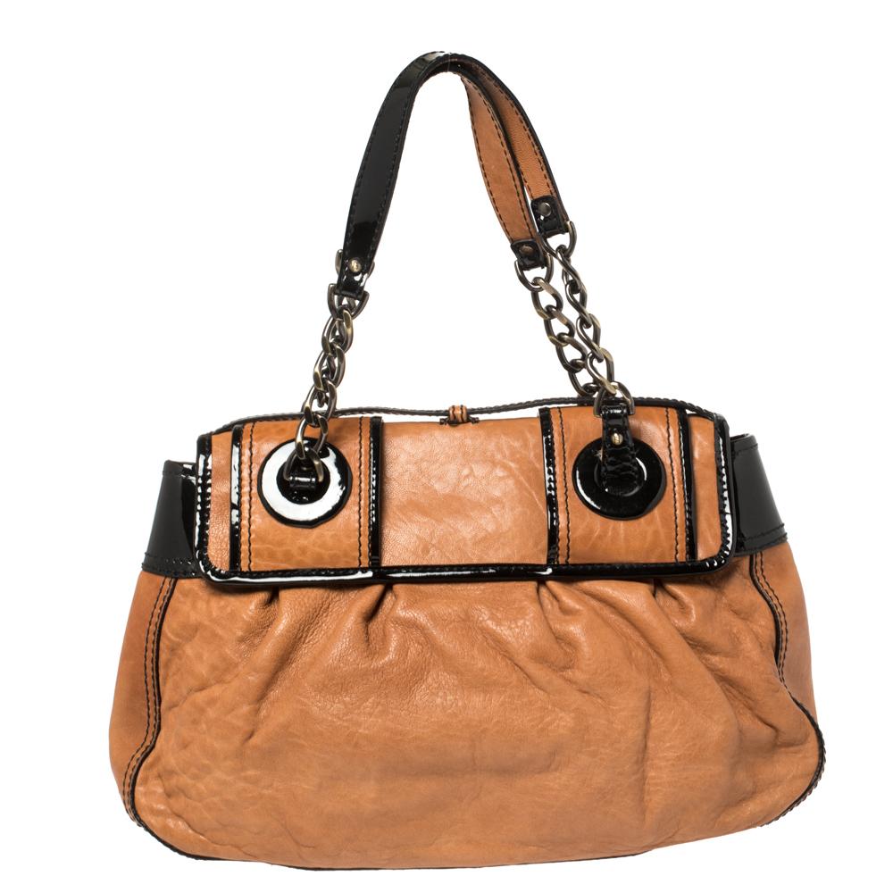 Fall in love instantly with this gorgeous B bag by Fendi. Made from brown and black leather and patent leather, this piece will smoothly last you season after season. It has two chain-leather handles, large buckle details on the front flap, and a