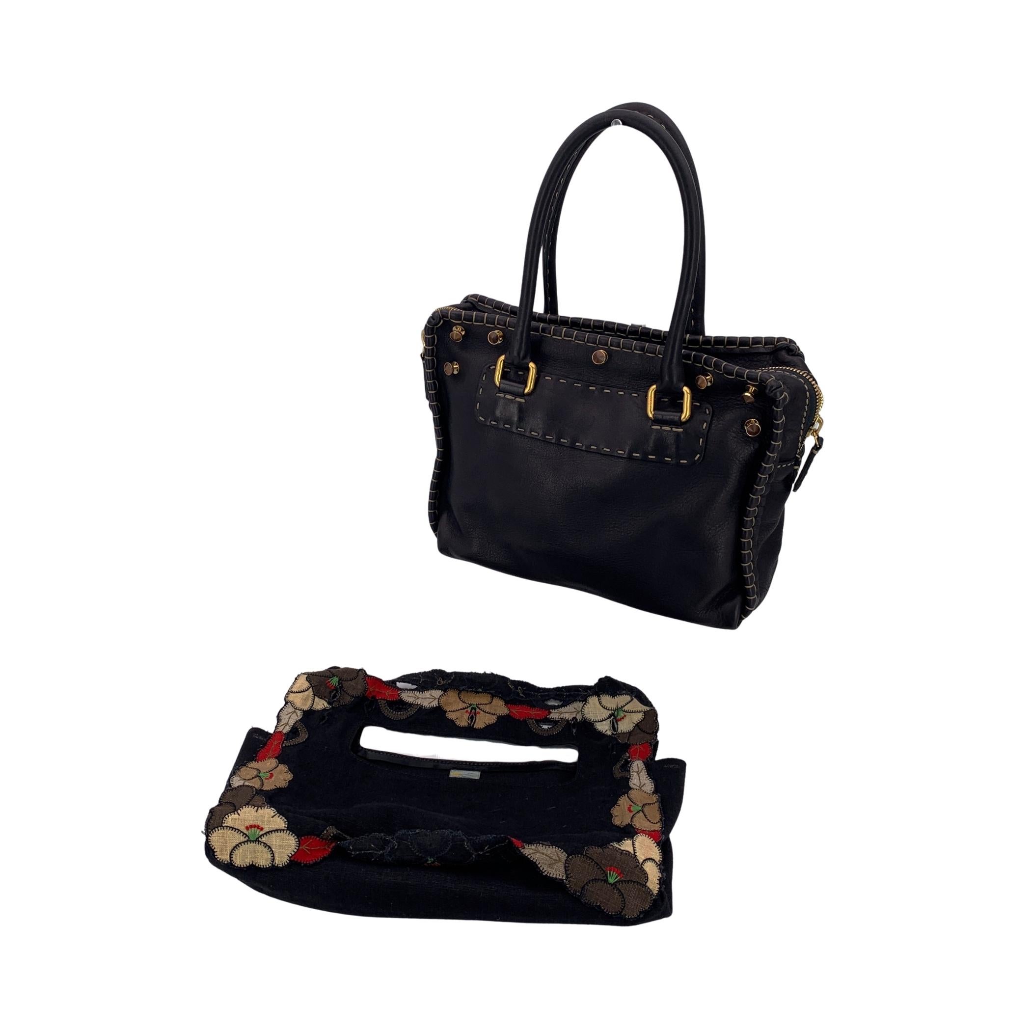 Sfrutta l'eleganza italiana senza sforzo con questa incantevole cartella in tela nera di Fendi, un mix di sobria eleganza e dettagli romantici. Delicate applicazioni floreali tracciano i bordi della borsa, ammorbidendo la sua silhouette strutturata