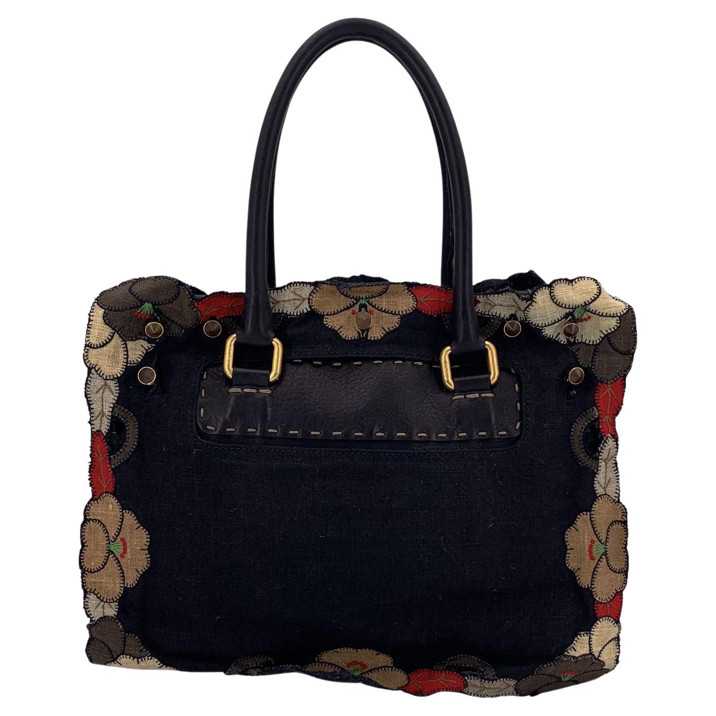 Fendi, borsa a cartella in tela e pelle nera con applicazioni floreali