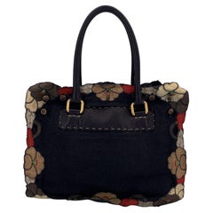 Fendi, borsa a cartella in tela e pelle nera con applicazioni floreali