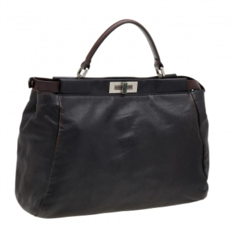 This Peekaboo bag from the House of Fendi is eternal, highly coveted, and impresses everyone with its shape, design, and beauty. This version comes meticulously crafted from black-dark brown leather, with a silver-toned logo-engraved lock on the