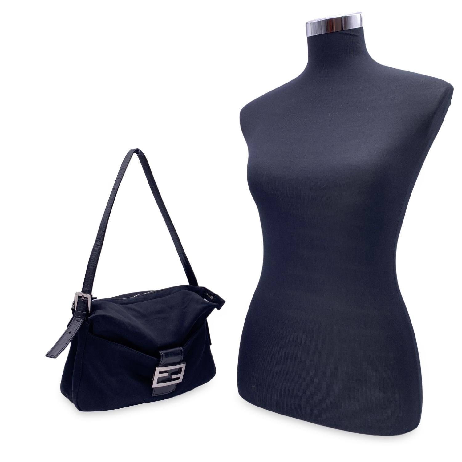 Wunderschöne 'Baguette Bag' von FENDI aus schwarzem Stoff mit Vordertasche. Fronttasche mit FF-Hardware-Schnappverschluss. Oberer Reißverschluss. Innentasche mit Reißverschluss. Verstellbarer Ledergriff oben. Diese täuschend kleine Tasche mit ihrem