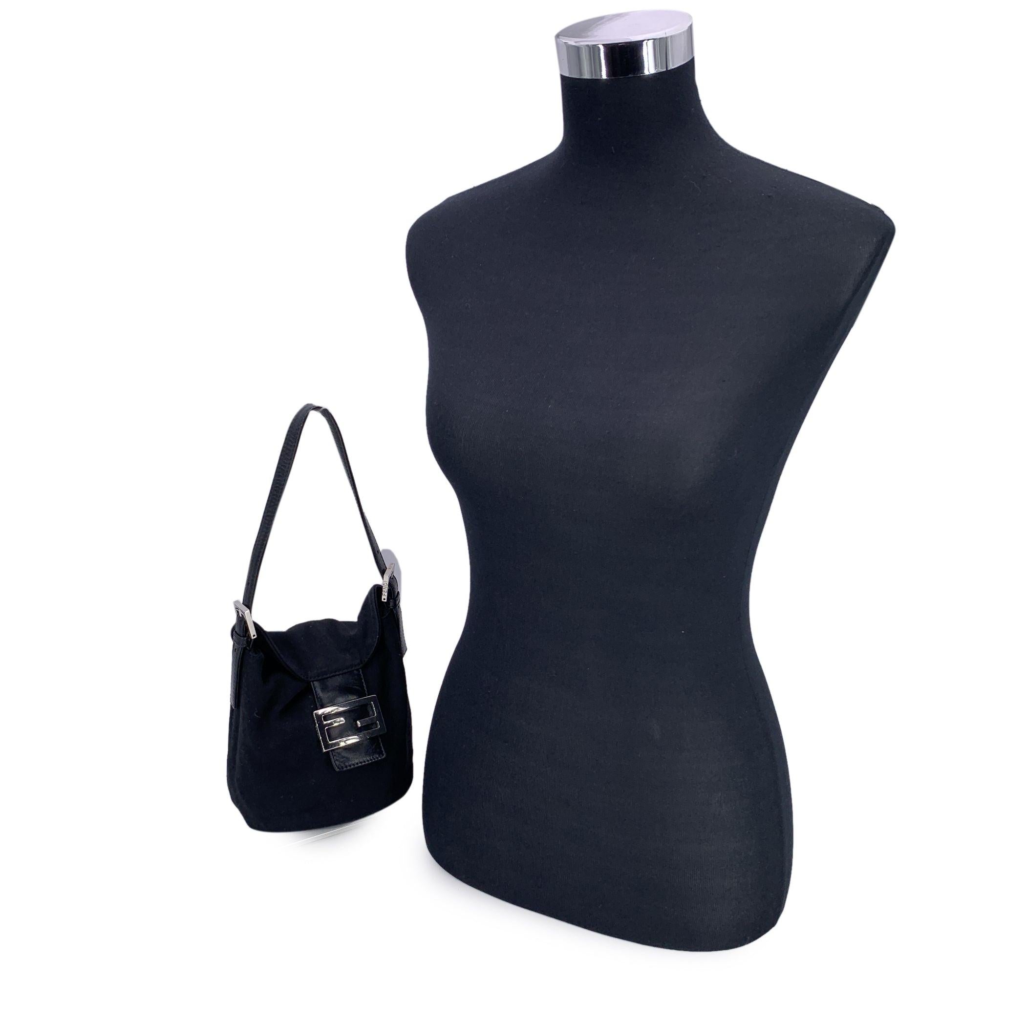 Tucked beneath the arm like its namesake French loaf, this Mini Baguette Bag by FENDI is a petite powerhouse of style and history. Crafted in sleek black fabric with a minimalist silhouette, it's a nod to the effortless chic of late '90s fashion.