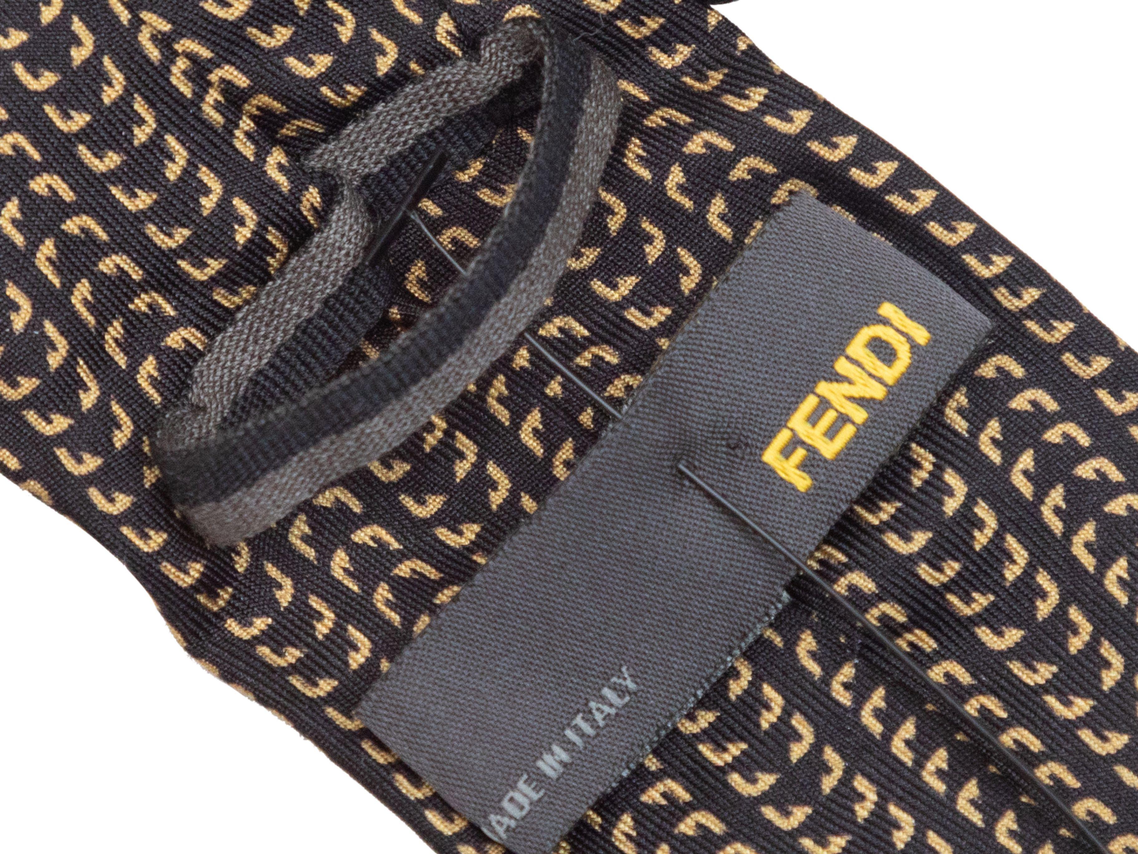Product Details: Black and gold monster eye print silk necktie by Fendi. 2.35