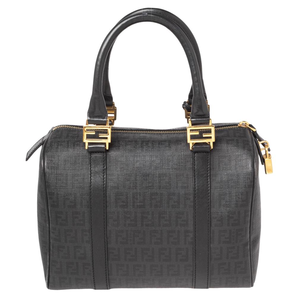 This elegant Forever Bauletto Boston bag from Fendi is crafted from Zucchino canvas and is perfect for daily use. The beautiful bag features details in the form of patent leather trims, dual top handles, and a gold-tone padlock. The top zip closure