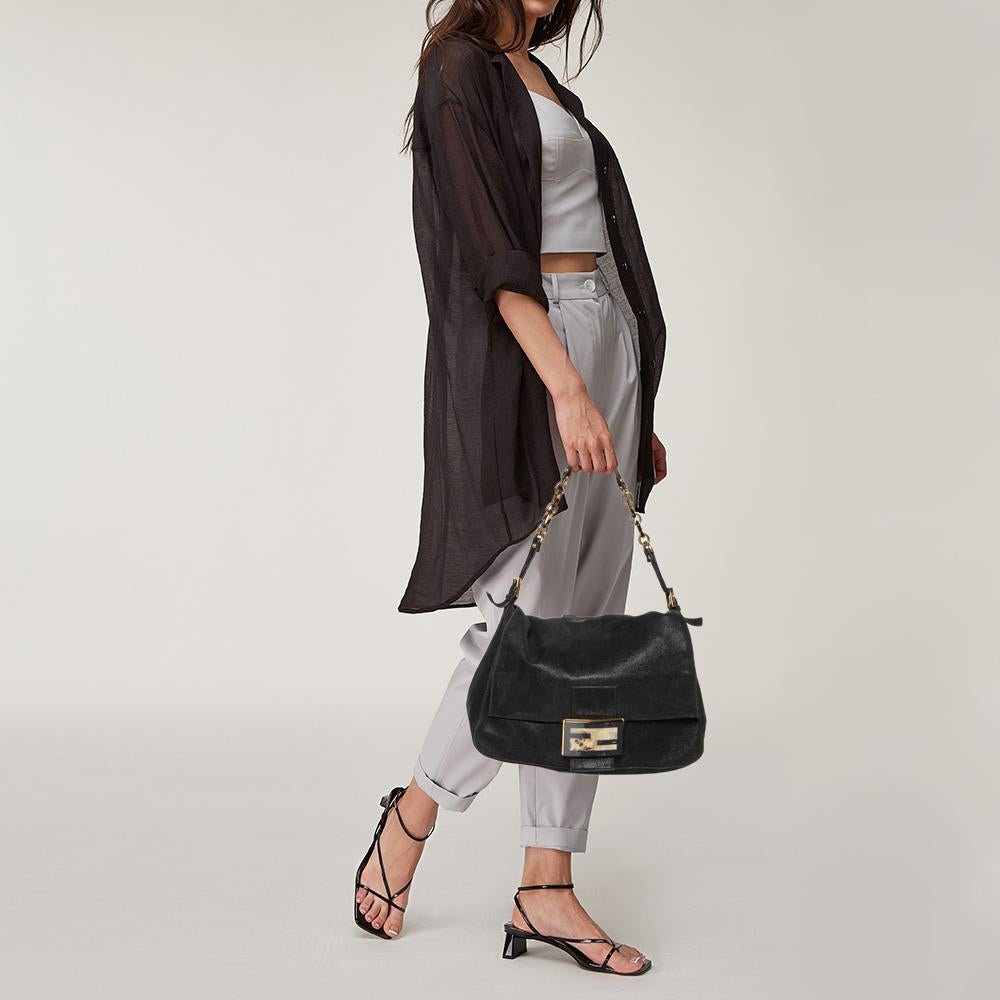 The Mama Forever shoulder bag from Fendi is a classic fashion choice. Detailed with their logo lock on the flap, this black iridescent leather bag is simple and stylish. A well-sized satin interior and a leather chain handle complete the bag.

