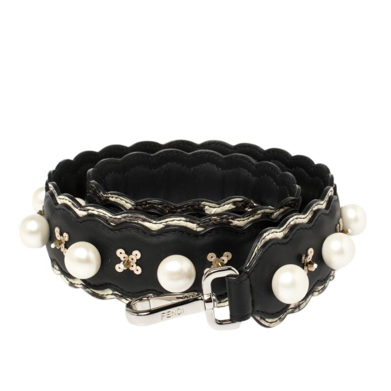 This stunning and functional bag strap hails from the house of Fendi. It has been crafted from quality leather and comes in a lovely shade of black. It has faux-pearl embellishments, impeccable detailing, and clasps at each end that easily attach to