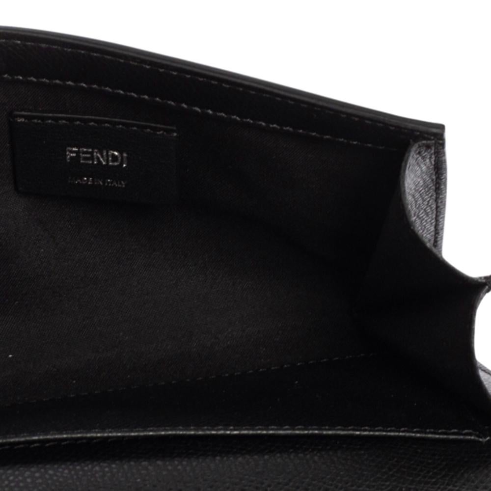 Crafted from leather, this black chain wallet from Fendi has a style that will catch glances from a mile. The F logo on the front adds to its beauty and makes it a worthy buy. It has been designed with a front flap that opens to a fabric-lined
