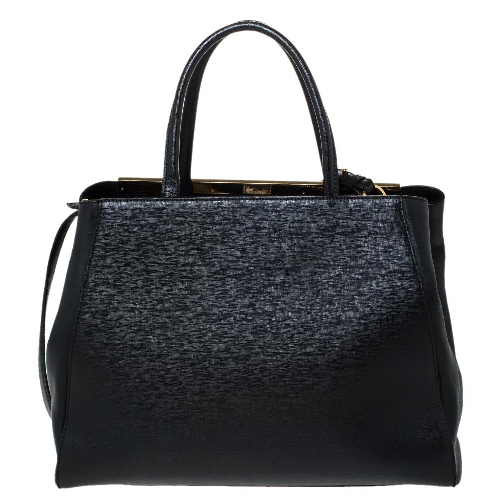 La tote 2Jours di Fendi è un design iconico. Realizzata in pelle nera, la borsa presenta una barra di metallo, due manici arrotolati e una tracolla staccabile. Una chiusura a bottone apre a uno spazioso interno foderato che ospita due scomparti