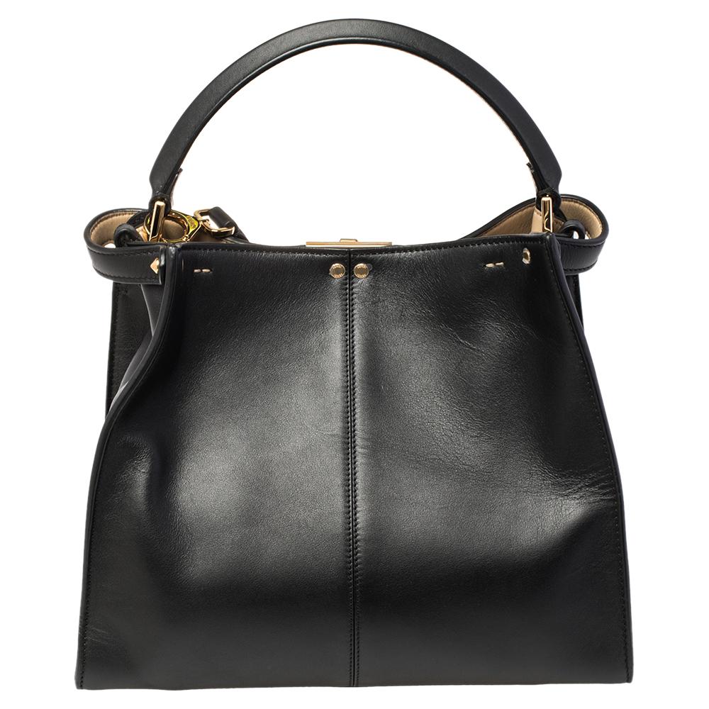 This exquisite Peekaboo X-Lite bag from Fendi is a great update of an iconic design. This version comes meticulously crafted from black leather and is designed with a top handle for you to swing it in style. A twist-lock opens grandly into a