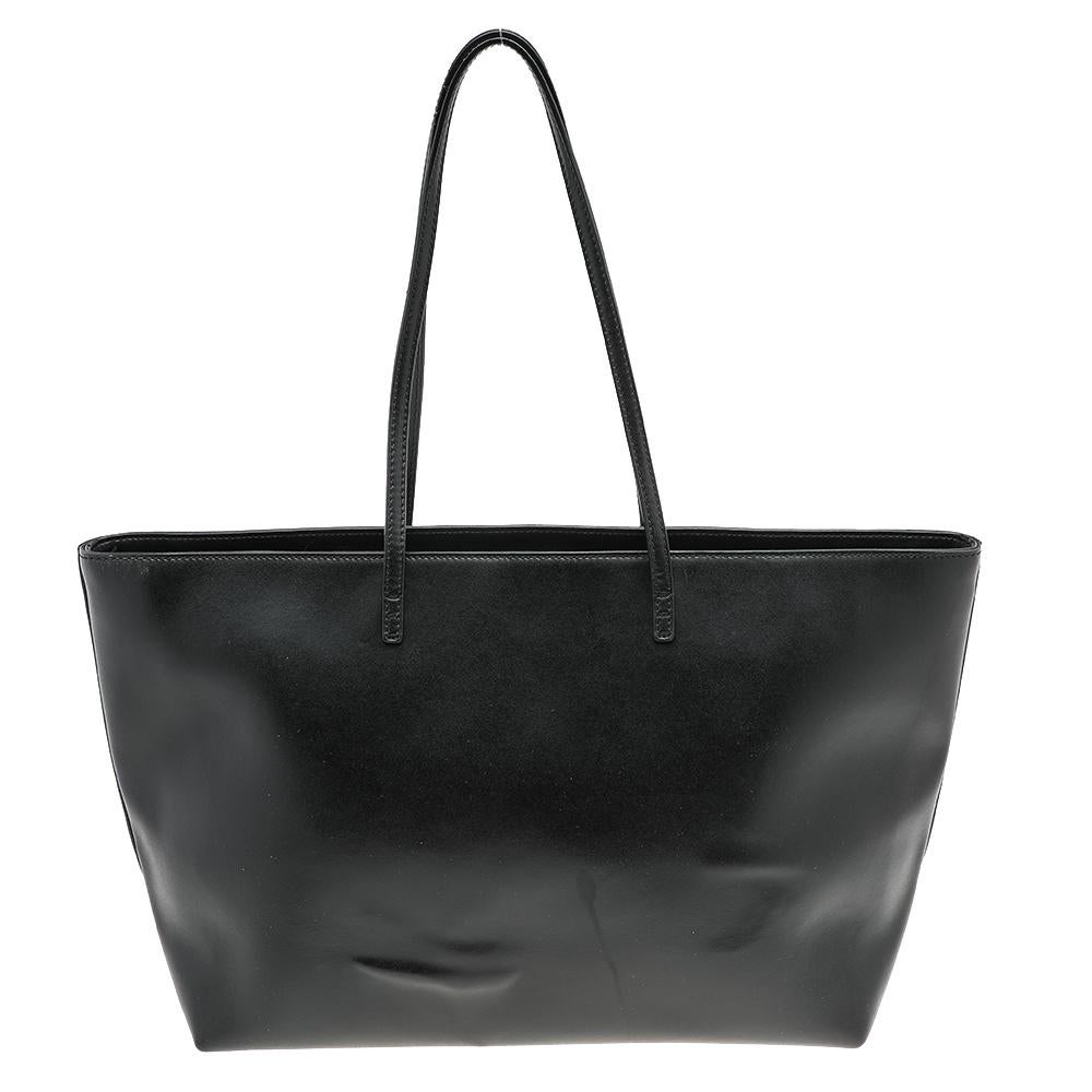 Funktional und stilvoll ist diese Tasche von Fendi. Sie wurde aus Leder gefertigt und in einem schwarzen Farbton mit Monsteraugen und einem Reißverschluss auf der Vorderseite gestaltet. Die Tasche wird von zwei Griffen gehalten und ist mit einem