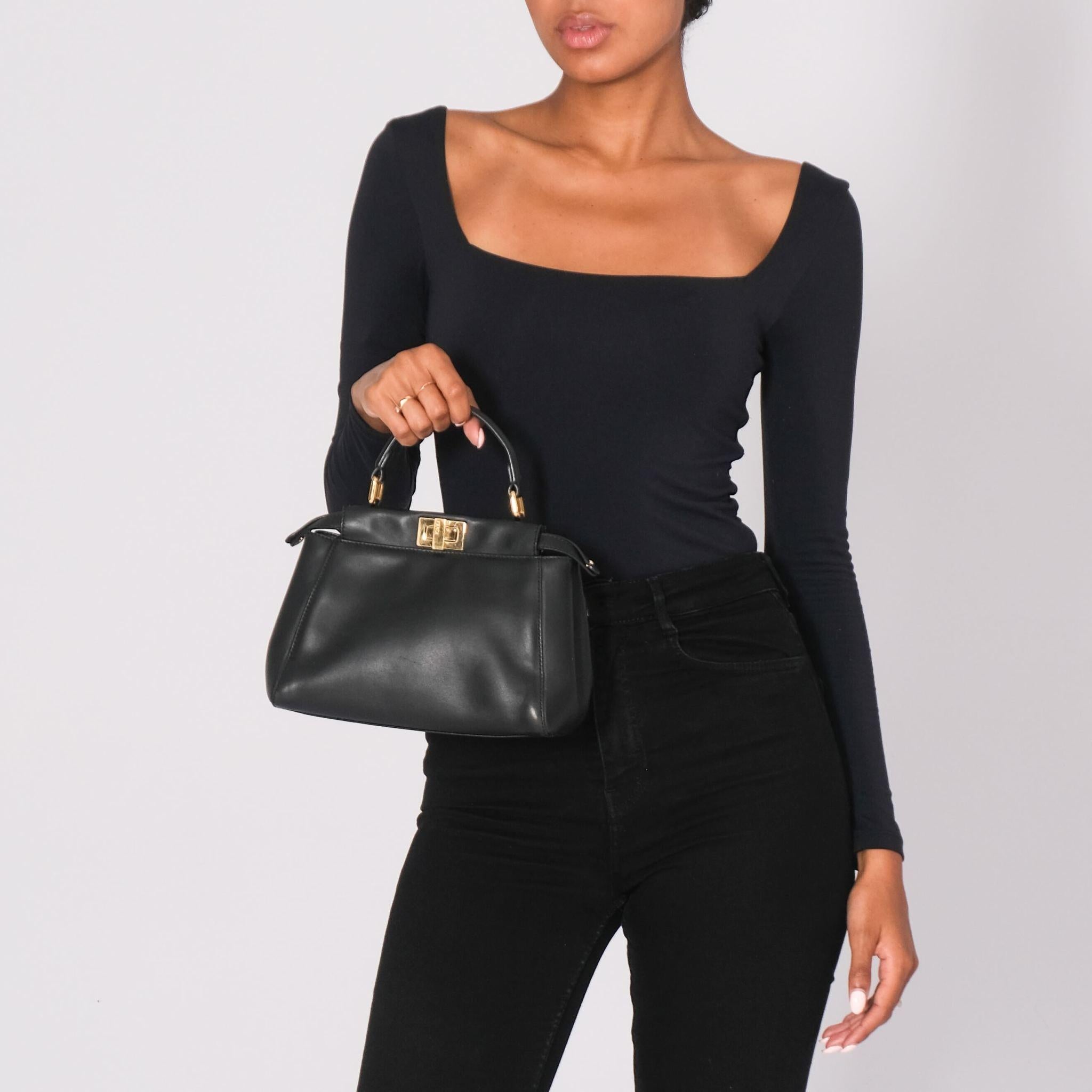 Fendi top handle bag. From the 2019 collection. Black leather. Gold-tone hardware. Single adjustable shoulder strap. Leather lining & three interior pockets. Turn-lock closures at front & back. Vintage.

Color: black with gold hardware
Material: