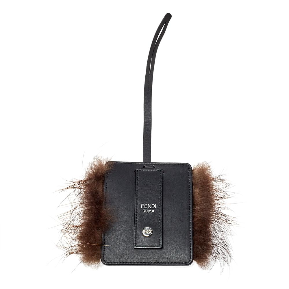 Adorable and playful, this luggage charm by Fendi features a small black leather silhouette featuring the signature Monster eye detail with studs. The charm is held by a leather strap and can be attached to your luggage easily.


Includes: Original