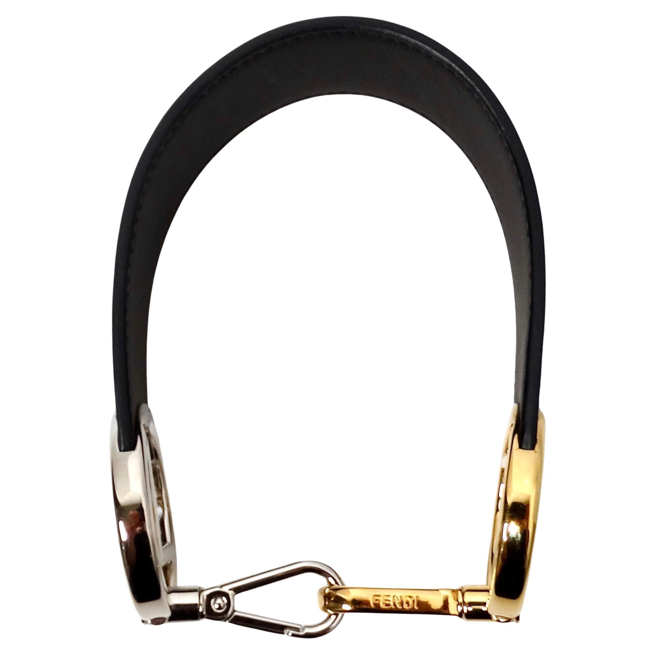 La bandoulière du petit sac en cuir noir à logo bicolore de Fendi est un accessoire luxueux et polyvalent qui rehausse tout sac à main ou pochette grâce à son design élégant et à ses détails sophistiqués. Réalisé en cuir noir de haute qualité, ce
