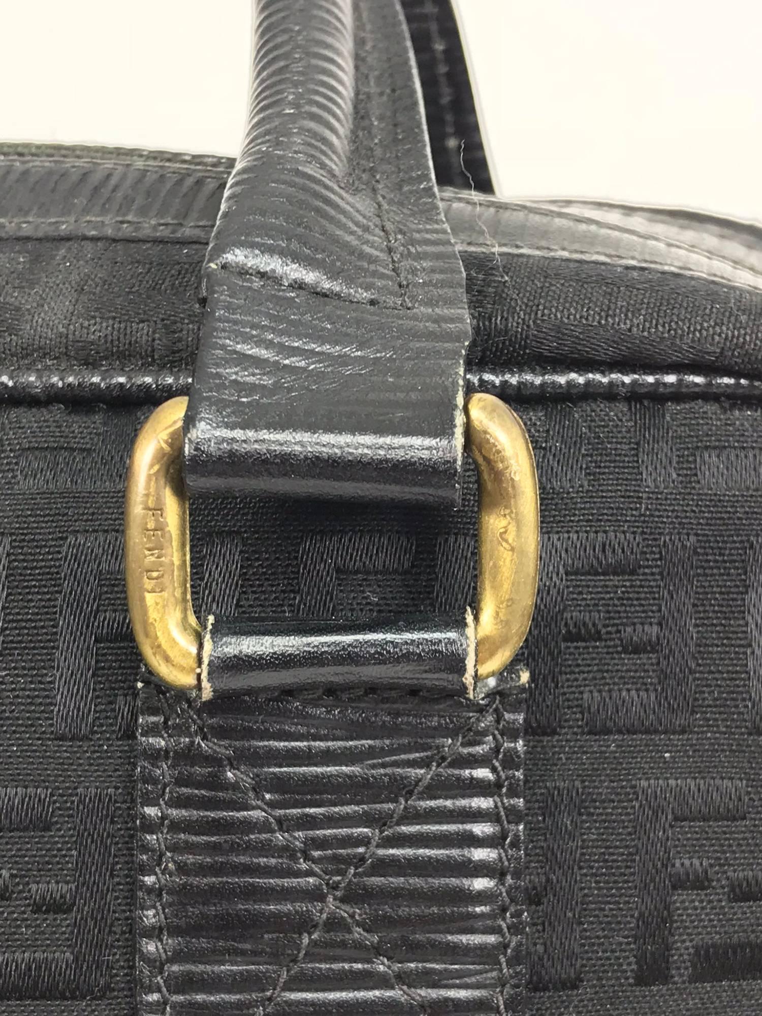 Fendi  black on black logo canvas and leather double handle handbag from the 1970s...Double leather handle bag has a double zipper top closure with a logo pull tabs...Leather trims...Interior in black faux leather with Fendi stamp in gold, a single