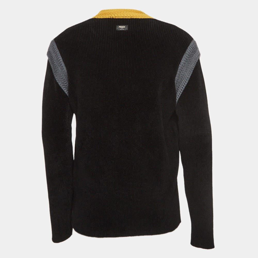 The Fendi sweater is a luxurious blend of comfort and style. Crafted with meticulous detail, it features a black base adorned with vibrant multicolored patterns. The knit fabric provides warmth, while Fendi's iconic craftsmanship ensures a