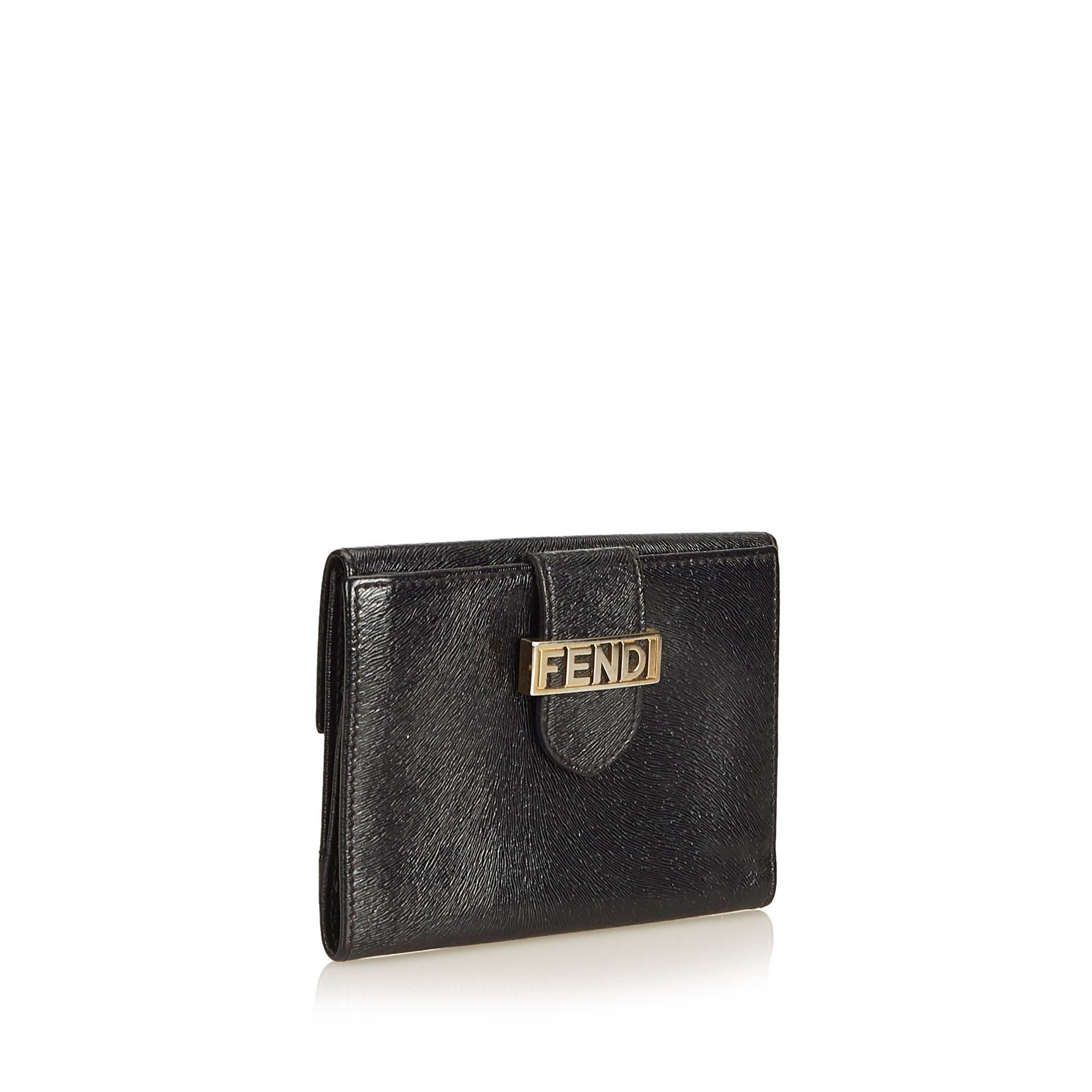 This small wallet features a leather body, flat strap with gold-toned hardware and button clasp closure, and interior slip pockets. It carries as B+ condition rating.

Inclusions: 
This item does not come with inclusions.

Dimensions:
Length: 9.50