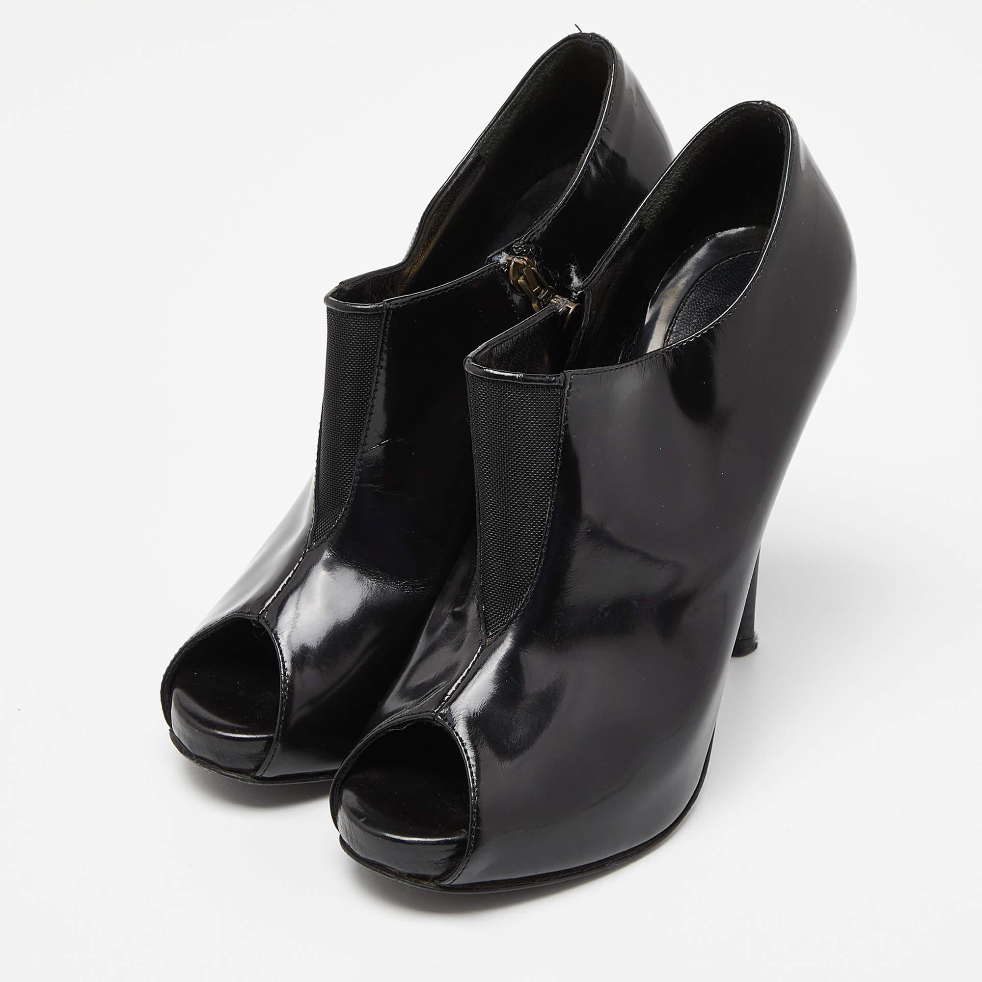 Les bottines Fendi présentent un luxueux mélange de matériaux, avec du cuir verni brillant et de la maille respirante. Le design à bout ouvert ajoute une touche de modernité tandis que la couleur noire respire la sophistication. Ces bottines allient