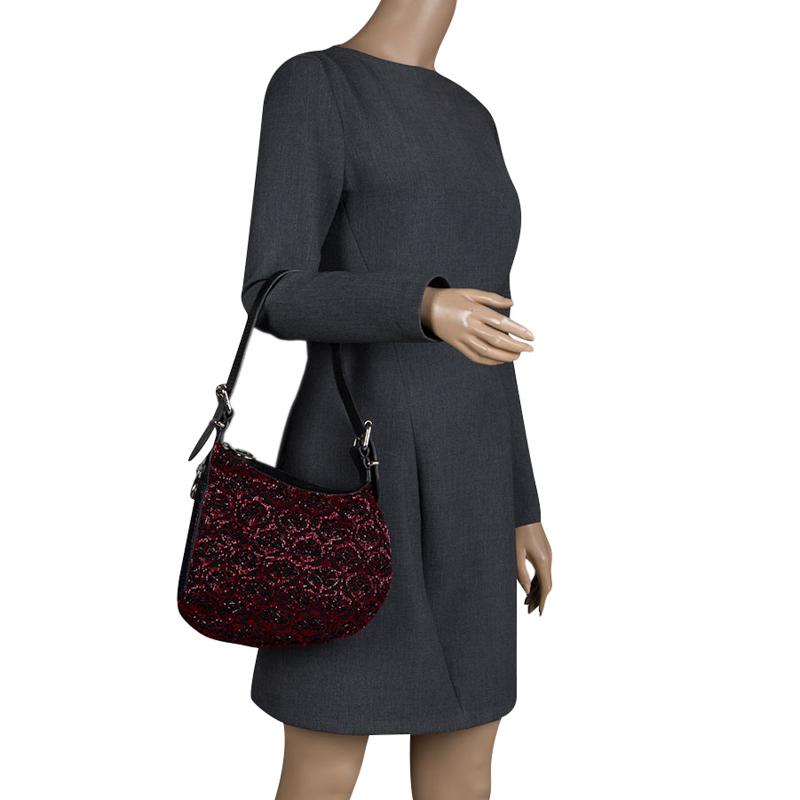 Carry a creation of wonder in your arms by choosing this Fendi piece which has been meticulously crafted from fabric and lizard skin. The hobo, with its zipper detailing and distinct shape, is further beautified by beads all over. A shoulder strap