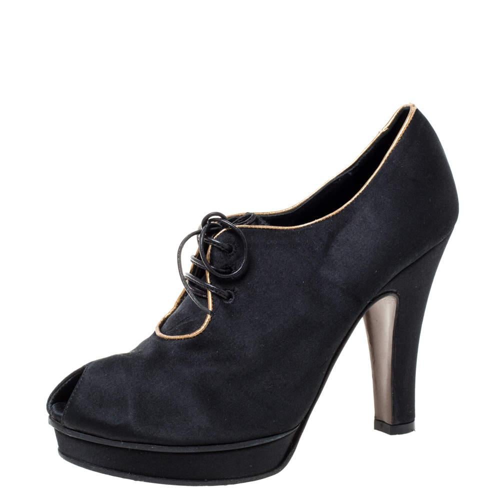 Estos botines de Fendi, elaborados con gran belleza, aportan la combinación perfecta de comodidad y moda. Diseñados con peep toes y cierre de cordones, estos botines de satén negro tienen plataforma y tacón de 11 cm.