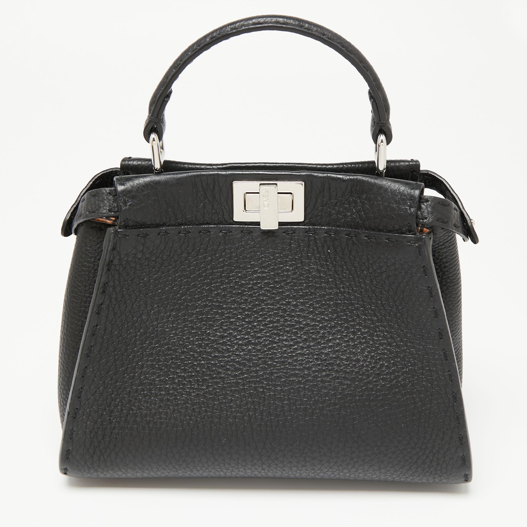 This exquisite Peekaboo from Fendi comes meticulously crafted using leather and is designed with the Selleria motif, a top handle, and a strap. Twist locks open to lined compartments to complete the bag's beautiful blend of luxury and practical