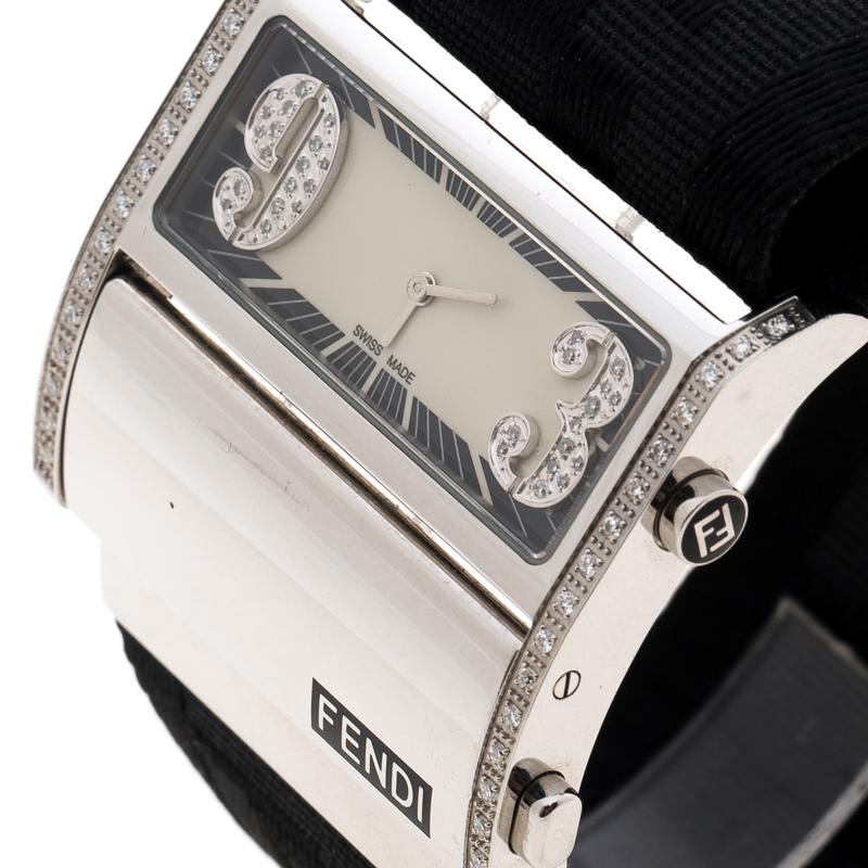 Uber-chic and high on trend, this timepiece is a Fendi creation. Swiss made, it has a stainless steel case held by an FF fabric strap with a hinged clasp. The watch has a black dial with diamonds set on the huge Roman numerals at 9 and 3 and on the