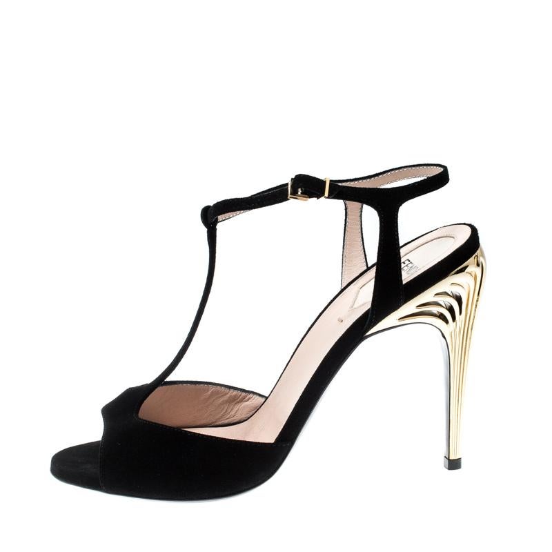 Styled with precision, this black Fendi number is crafted in suede as a t-strap and completed with buckle closures at the ankles. The peep toes, coupled with the artful detailing on the 11.5 cm gold-tone heels make them a pair that's chic and