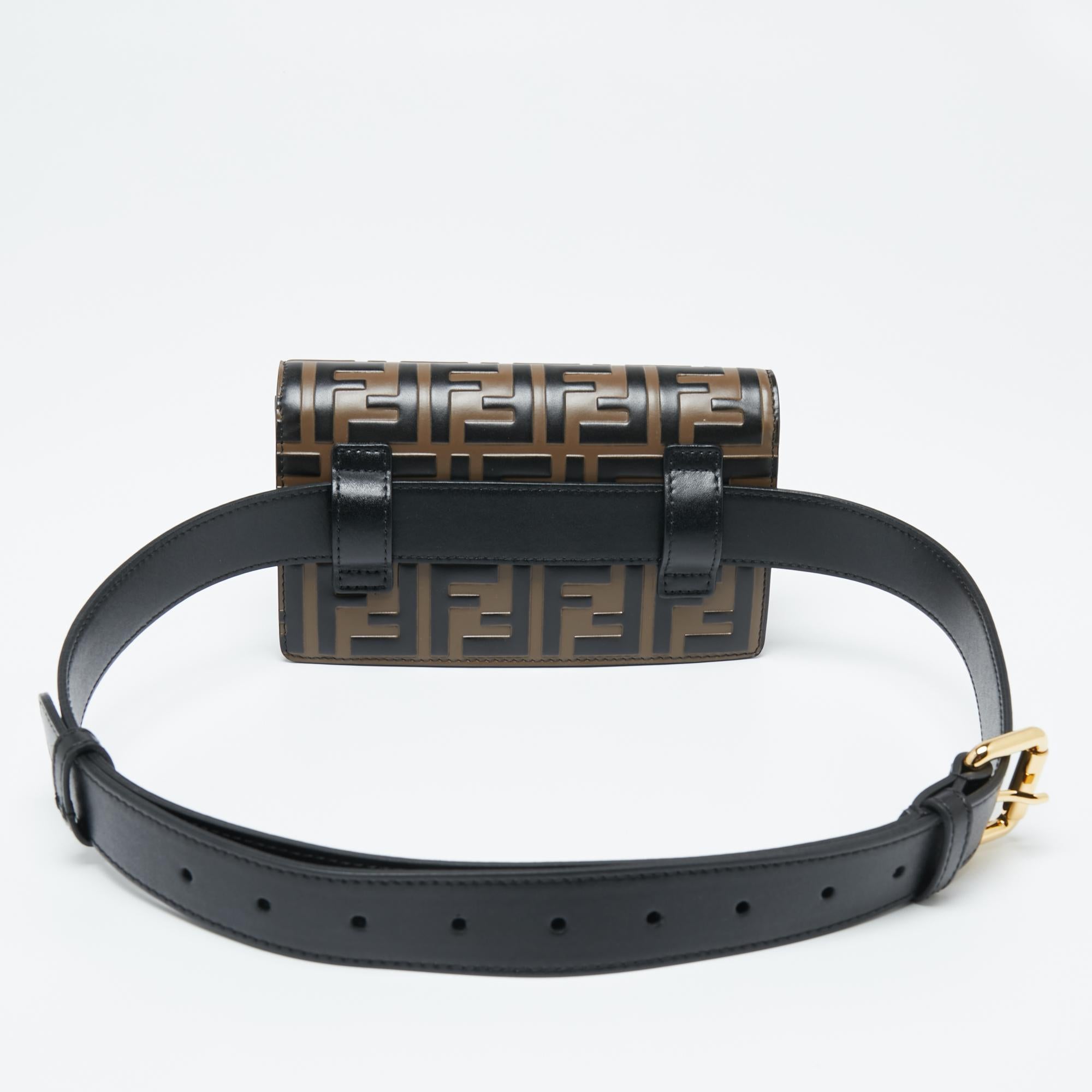 This Fendi belt bag blends a modern style with a popular House design—Kan I. Crafted from black and Tobacco Zucca leather, the belt bag has a lined interior, a metal chain, and a leather belt.

Includes: Original Dustbag, Chain Strap