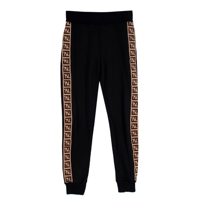 Fendi Schwarz mit braunen & beigefarbenen FF-Seitenstreifen Track Pants
 

 - Schwarze Jogginghose mit seitlichen Riemen mit FF-Monogramm in Beige- und Brauntönen
 - Elastischer Bund und Bündchen
 - Zwei Eingrifftaschen auf der Vorderseite
 

