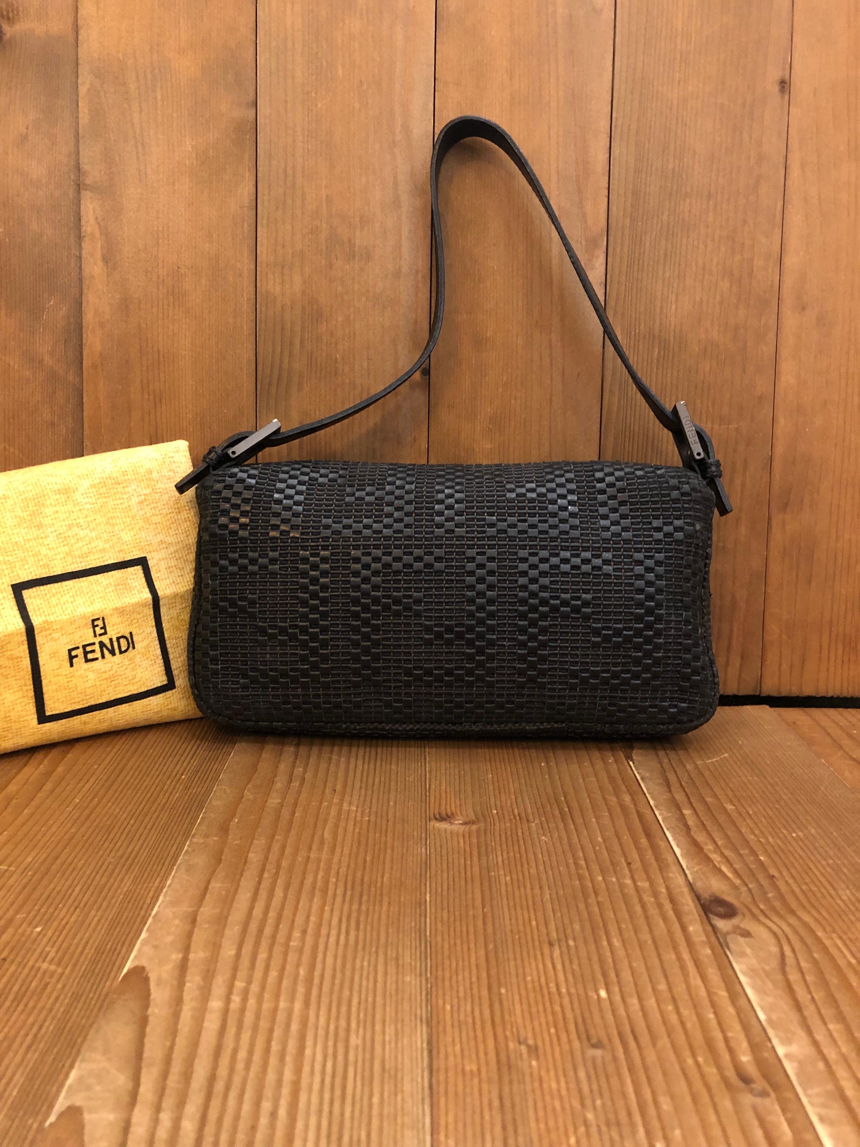 The iconic Fendi Baguette hand bag is crafted of dark brown leather woven in Zucca pattern featuring one interior zip pocket. Made in Italy. Magnetic snap fastening. Measures 10 x 5.5 x 1.5 inches Drop 7.5 inches. Comes with dust bag.

Condition: