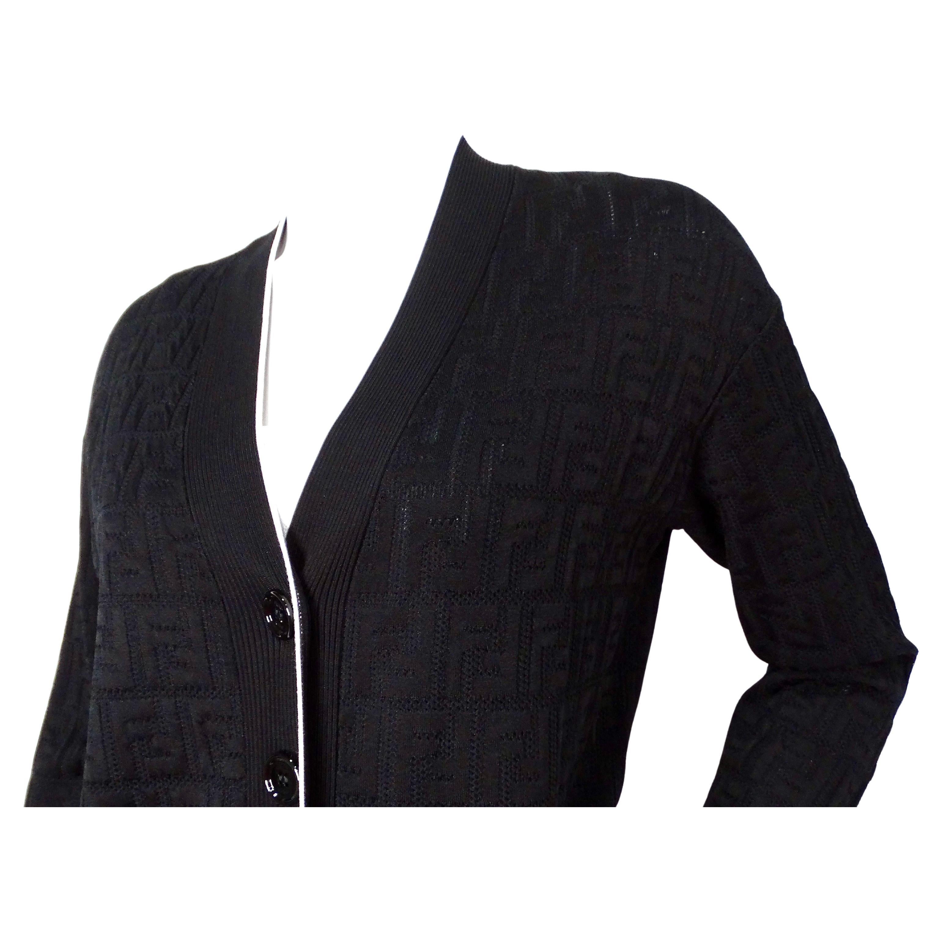 Der Fendi Black Zucca Monogram Knit V-Neck Cardigan ist ein raffiniertes und vielseitiges Modell, das Luxus und Komfort nahtlos miteinander verbindet. Es ist aus einer Mischung aus Baumwolle und Viskose gefertigt und bietet ein weiches,