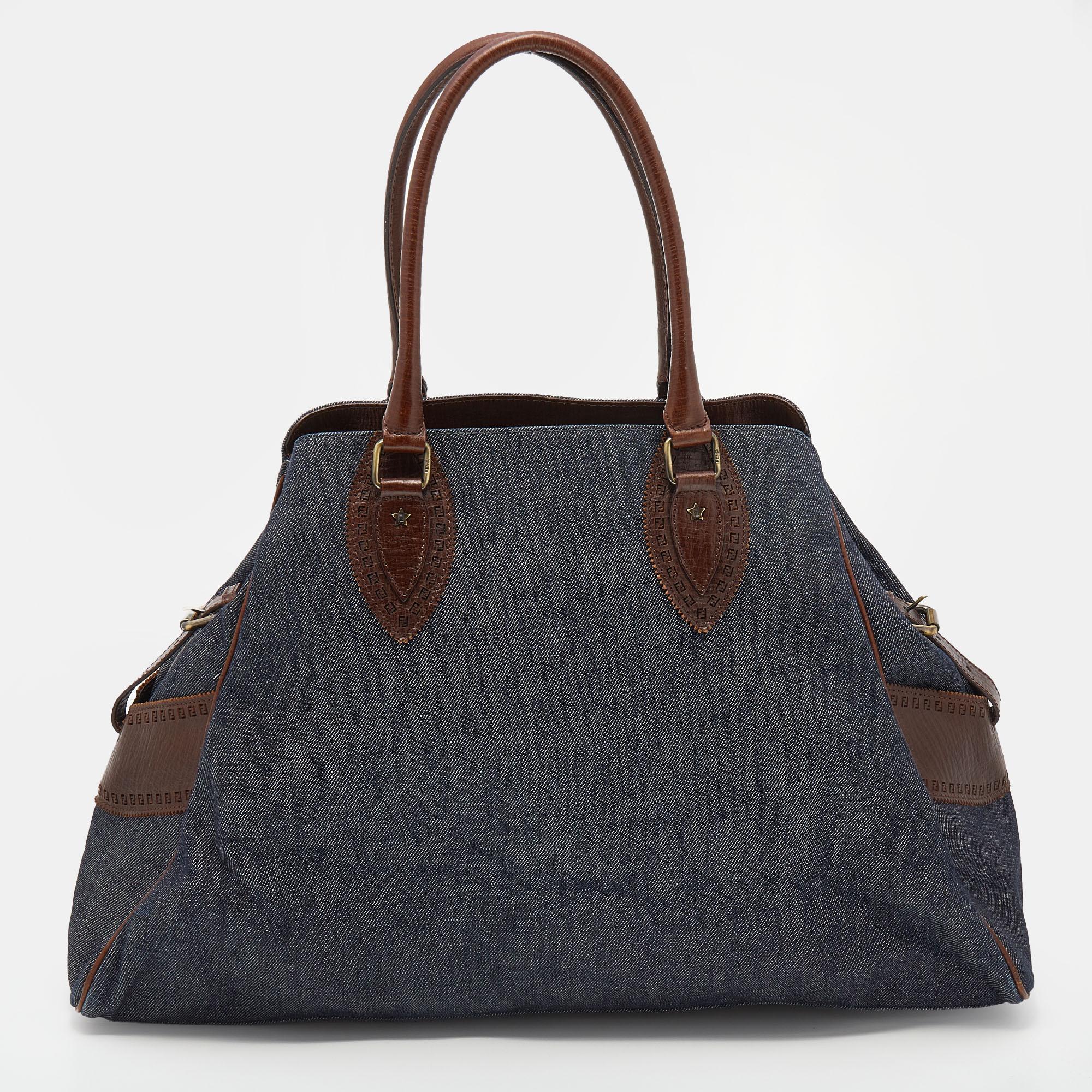 This gorgeous satchel from Fendi is crafted from denim and leather and is enhanced with brass-tone hardware. It comes with dual handles and shows a chic shape. The bag is lined with satin on the inside and will easily hold your necessities with