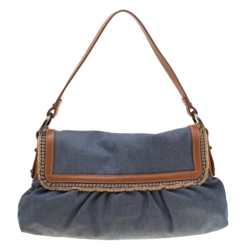 Go for a basic yet chic look with this Fendi flap bag. Made from blue denim, the exterior features a flap front with brown leather and fringed trim accented with a Fendi charm with a leather strap on the front. It comes with a single shoulder strap.