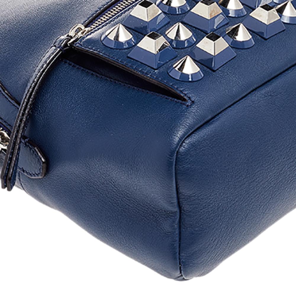 Get set to carry your essentials with complete ease using this shoulder bag designed by Fendi. It has been crafted from blue leather and enhanced with silver-toned studs. It is featured with a top handle, a 45 cm shoulder strap, and a frontal zip
