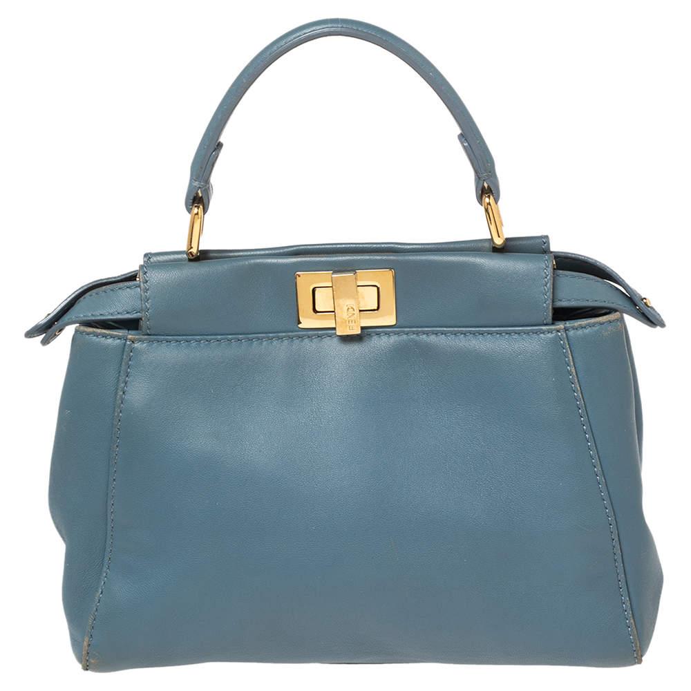 This exquisite mini Peekaboo from Fendi comes meticulously crafted using leather and is designed with a top handle and a shoulder strap. Twist locks open to compartments lined with leather to complete the bag's beautiful blend of luxury and