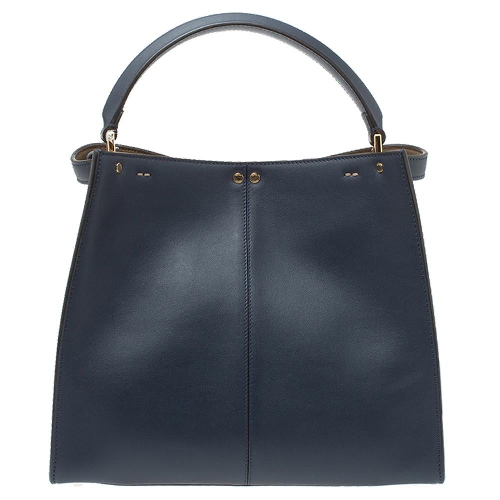 This exquisite Peekaboo X-Lite bag from Fendi is a great update of an iconic design. This version comes meticulously crafted from blue leather and designed with a top handle for you to swing it in style. A twist-lock opens grandly into a compartment