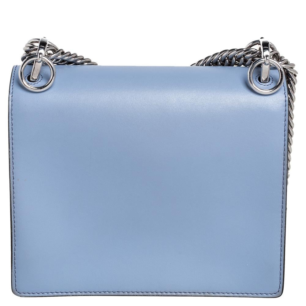 This stunning Kan I bag by Fendi has been crafted in Italy and will elevate your look instantly. It is made of leather and comes in a blue hue. With a sturdy silhouette, this bag is adorned with a studded lock that opens to reveal a suede-lined