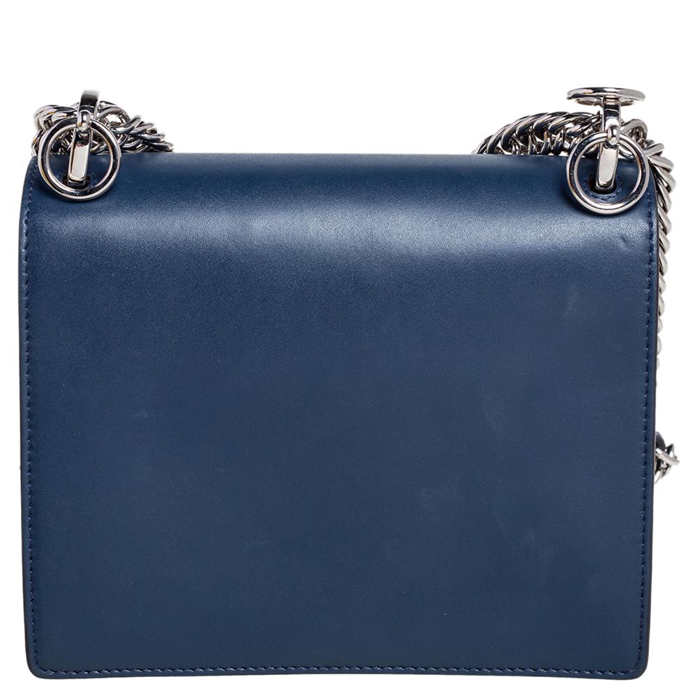 This stunning Kan I bag by Fendi has been crafted in Italy and will elevate your look instantly. It is made of leather and comes in a blue hue. With a sturdy silhouette, this bag is adorned with a studded lock that opens to reveal a suede-lined