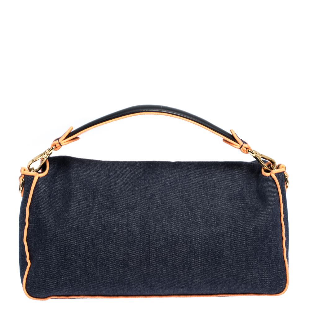 The Mama Baguette bag from Fendi is an all-time classic. Accented with the striking Forever lock in gold-tone on the front flap, the piece carries a blue & orange denim exterior and a spacious interior sized to hold all your essentials. A wide strap