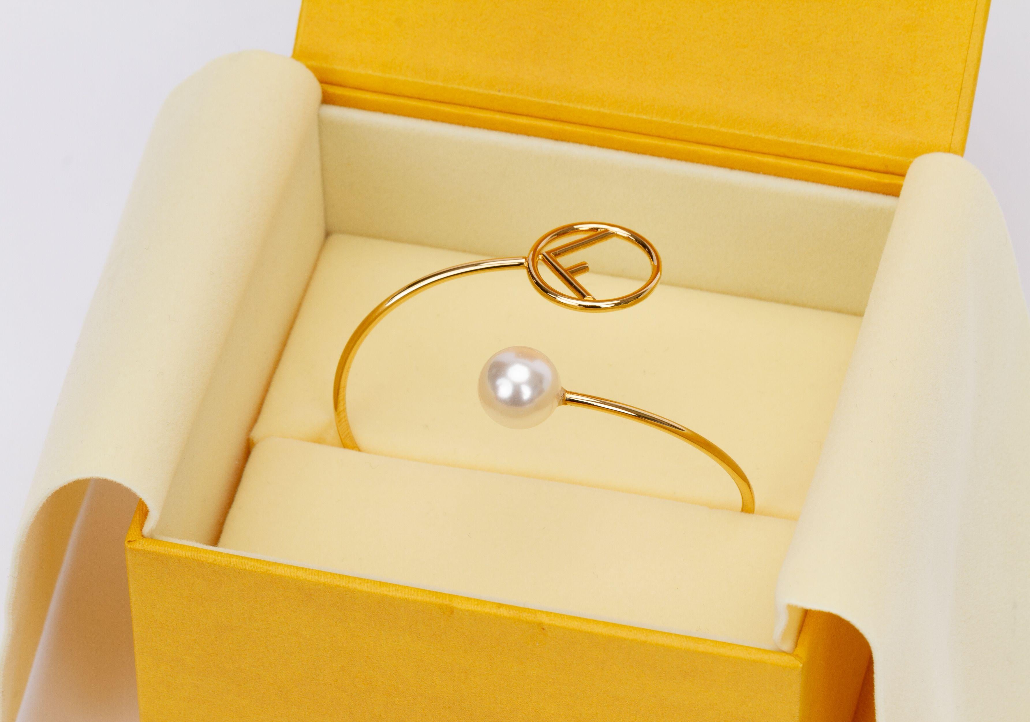 Fendi bracelet in gold. On one side the bracelet ends with a pearl and on the other side is singular F logo. It is new and comes with the original box.