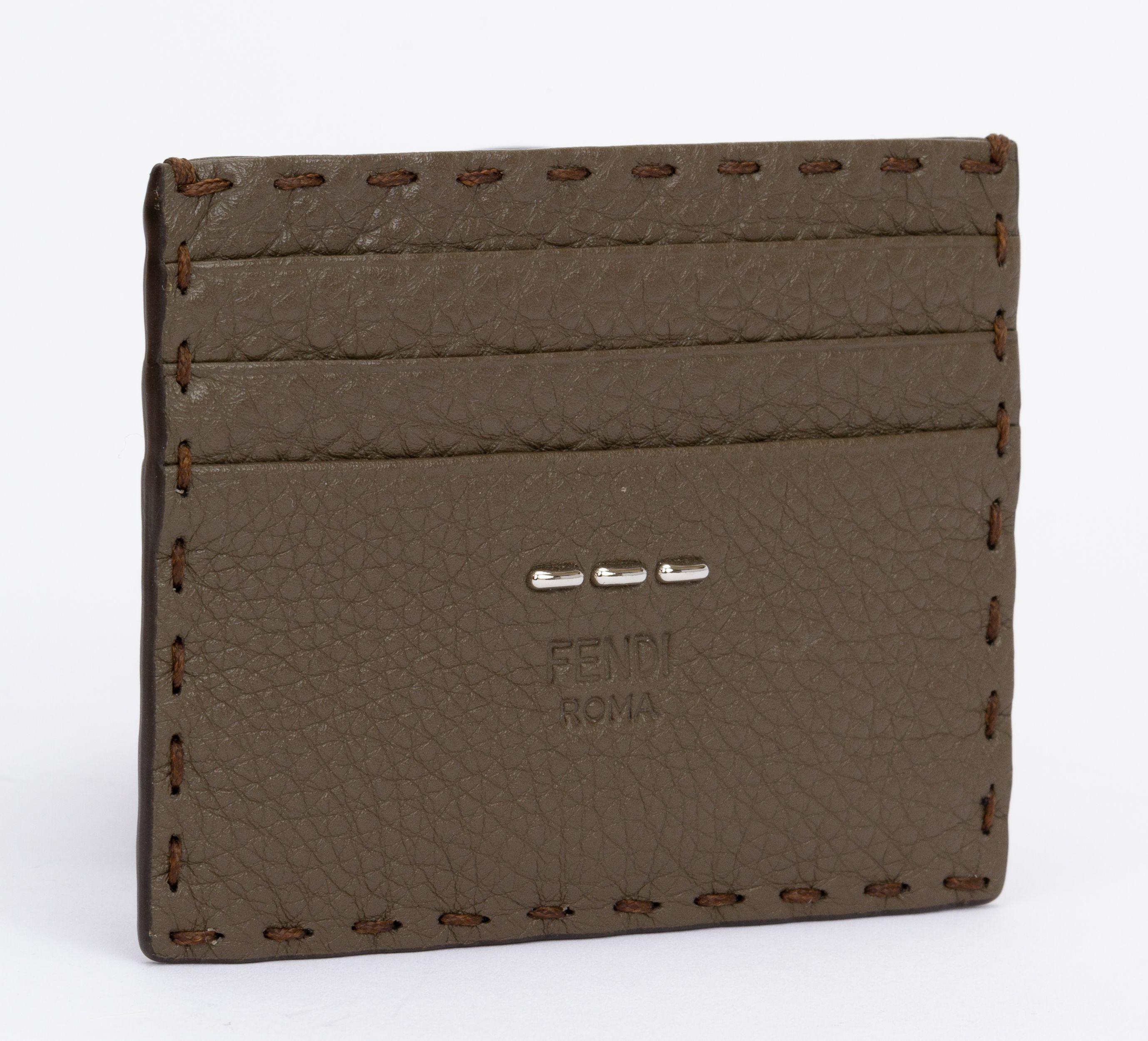 Fendi Selleria wallet made of leather in etoupe and the edges are stitched up. The piece has 6 card holders and is brand new. The piece includes the tag, booklet, original box and dust cover.