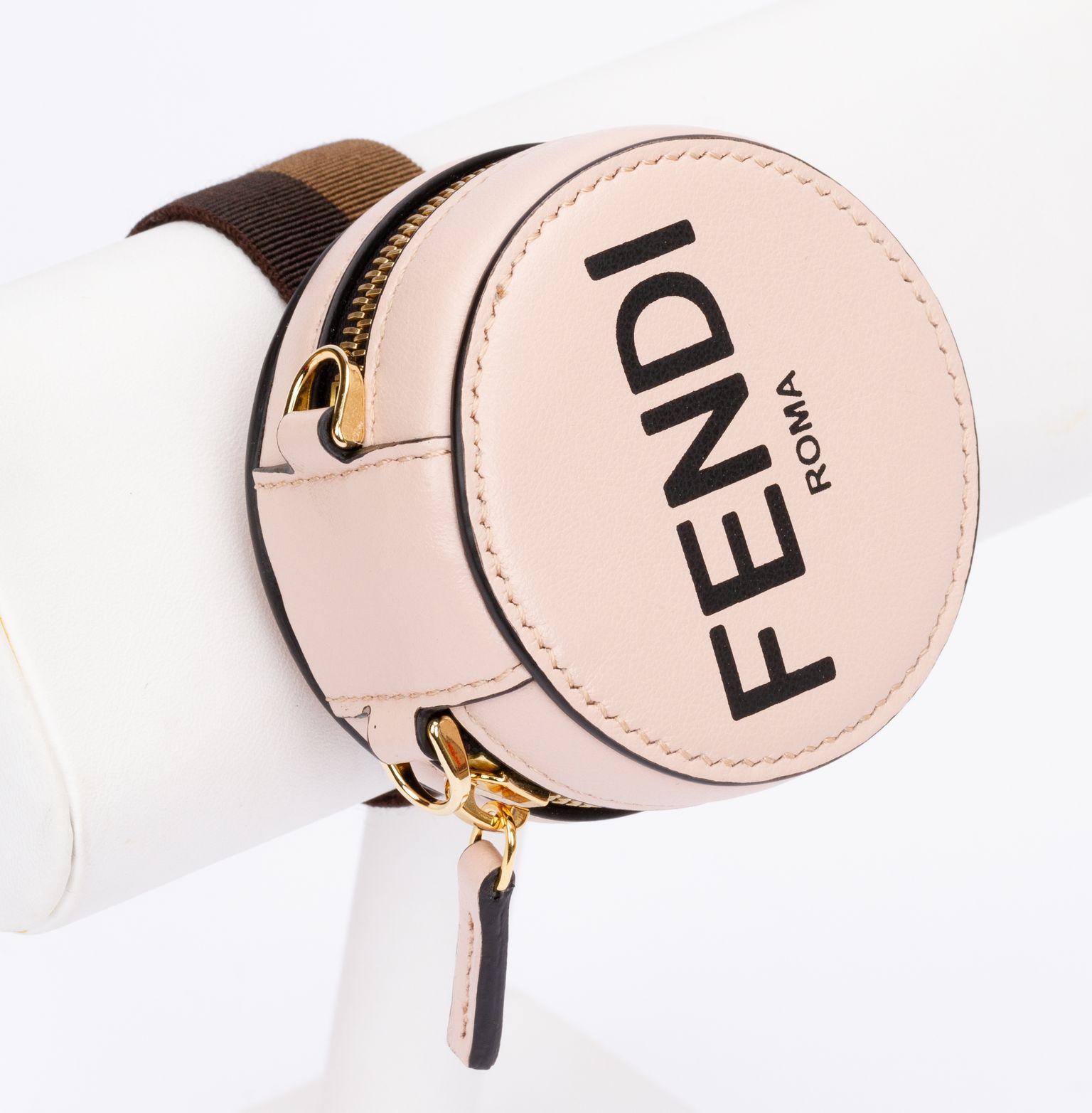 Fendi wrist band with zipped pocket in rosé made of leather. The charm is a round pocket and on top of Fendi is written on it. The pocket can also be used without the wrist band. It is new and includes the original box and dust cover.