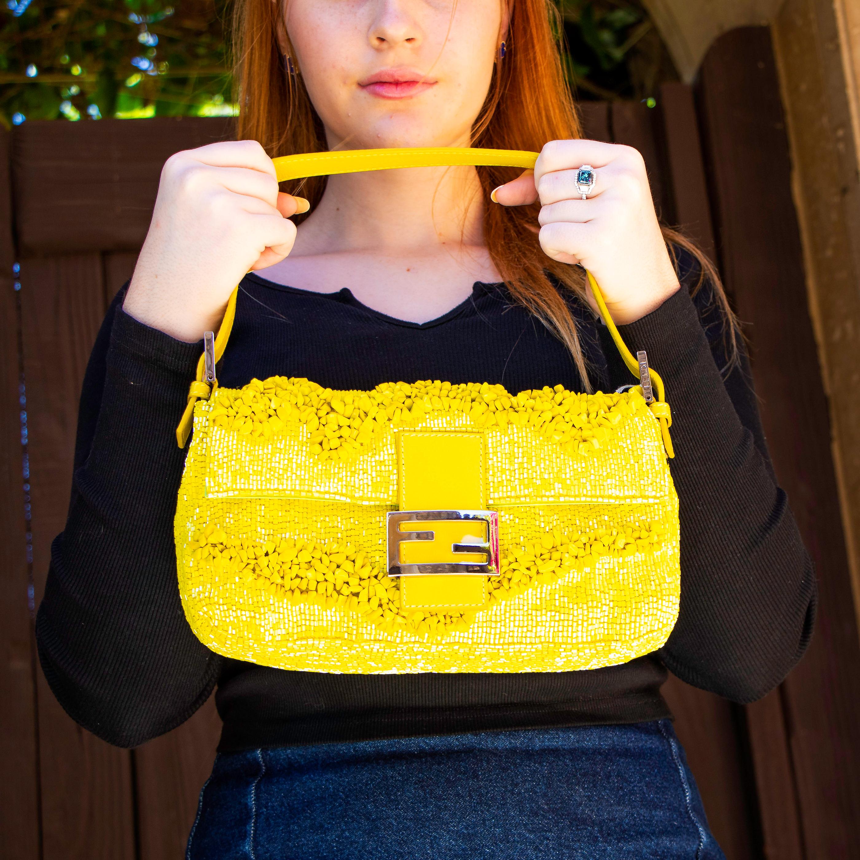 Beautiful bright yellow embroidered clutch with a yellow strap. This bag has one main pocket with a small zippered side pocket. It also comes with two different authenticity cards one for the leather, and the other for the craftsmanship of the