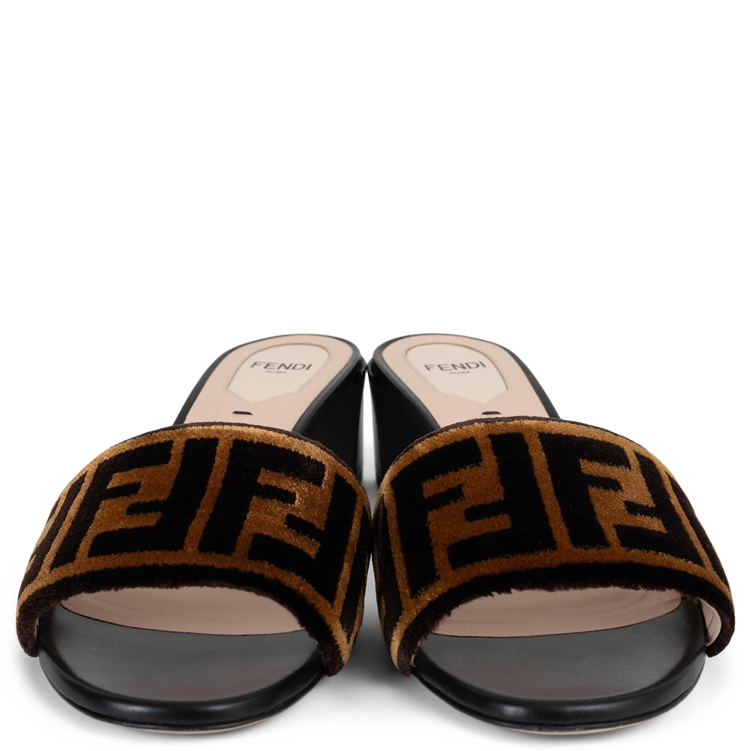 Questi sandali mulo di Fendi, autentici al 100%, sono realizzati in velluto bronzo e nero con logo Zucca, bilanciati da solette in pelle liscia e robusti tacchi a blocco. Il design open-toe e la silhouette slip-on offrono un'eleganza senza sforzo,